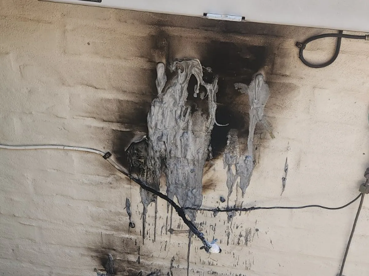 Severe electrical fire damage below exterior electrical equipment